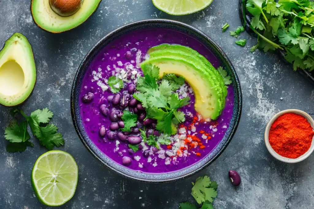 Vegan soup with purple-tinted black beans and fresh garnishes.