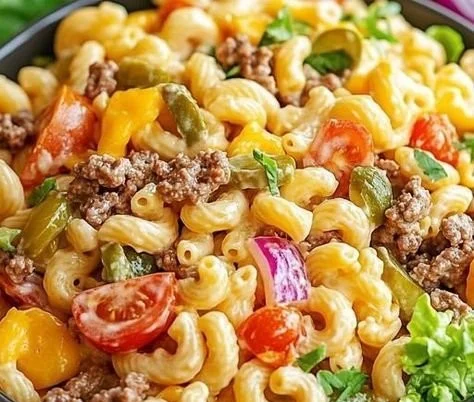 A bowl of Big Mac Pasta Salad with lettuce, pasta, and burger toppings.