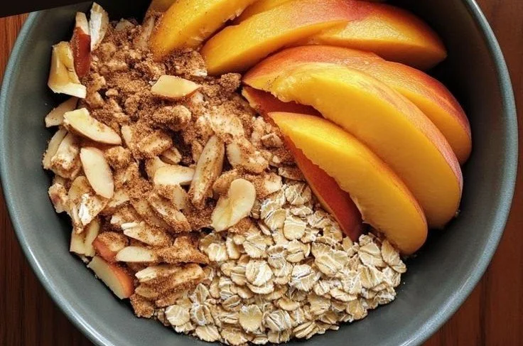 Bowl of easy cinnamon peach oatmeal mix topped with fresh peaches and cinnamon