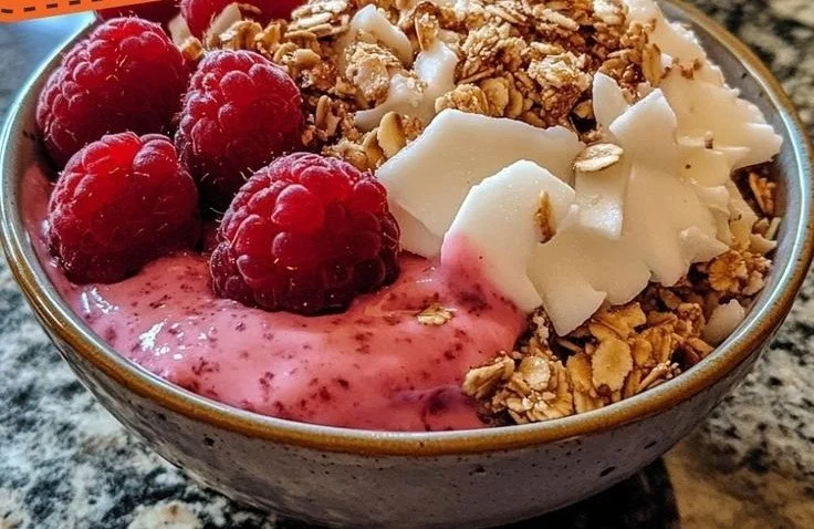 Delicious Raspberry Coconut Crunch Bowl topped with fresh raspberries and coconut flakes.